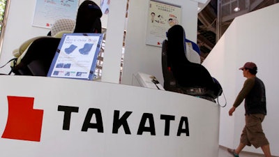 In this Wednesday, May 4, 2016 file photo, a visitor walks past child seats, manufactured by Takata Corp., displayed at an automaker's showroom in Tokyo. A criminal complaint has been filed in Japan about a Takata air bag causing injuries during a crash, the first such case in this nation related to an unfolding massive recall. Takata Corp. said Wednesday, June 8, 2016, it was fully cooperating with the investigation of the accident, in which a woman in the front passenger seat of a Nissan X-Trail sport-utility vehicle was injured.