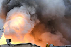 Los Angeles County Firefighters stand on top of a roof and watch as an explosion erupts from a factory in Maywood, Calif. on Tuesday, June 14, 2016. Explosions rocked a small Los Angeles County city early Tuesday as an inferno raged through a business containing metals and and firefighters decided to allow the blaze to burn itself out.