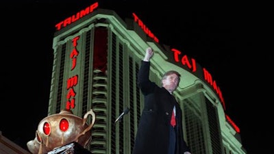In this April 5, 1990 file photo, Donald Trump raises his fist during ceremonies for the opening the Trump Taj Mahal Casino Resort in Atlantic City, N.J. Soon after the opening, Trump owed $70 million to 253 contractors employing thousands who built the domes and minarets, put up the glass and drywall, laid the pipes and installed everything from chandeliers to bathroom fixtures. The next year, when the casino collapsed into bankruptcy, those owed the most got only 33 cents in cash for each dollar owed, with promises of another 50 cents later. It took years to get the rest, assuming the companies survived long enough to collect.