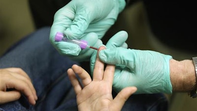In this Jan. 26, 2016 file photo, registered nurse Brian Jones draws a blood sample from a student at Eisenhower Elementary School in Flint, Mich. The students were being tested for lead after the metal was found in the city's drinking water. Blood-lead levels in Flint children under the age of 6 were significantly higher after the city switched its water in 2014 in a cost-saving move, according to report released Friday, June 24, 2016, by U.S. disease experts.