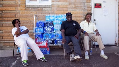 Stephanie Smith, left, Jimmie Thompson, center, and Otis Ross, right, share a laugh in-between residents coming to get water at Prince of Peace Baptist Church Wednesday, June 22, 2016 in northwest Flint. Every Monday, Wednesday and Friday the church gives out water for free from 10 a.m. to 2 p.m. 'My brother lives in Atlanta. I try to tell him he doesn't realize how bad the water crisis is here,' Ross said. 'You can't imagine it until you get here.'