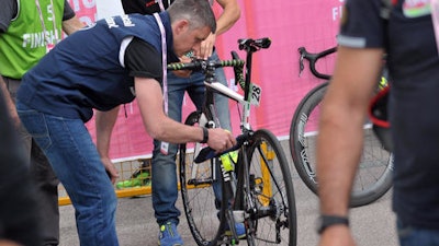 In this May 18, 2016 photo, a bicycle is inspected after arriving in Asolo, Italy after the 11th stage of the Giro d'Italia cycling race. There is perhaps no Olympic sport as dependent on technology as cycling, where space-age, feather-light carbon fiber bikes can cost more than a car _ and make the difference between a gold medal and nothing. That has also made the sport ripe for a new kind of doping: mechanical doping.
