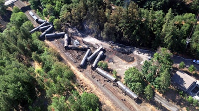 This aerial view provided by the Washington State Department of Ecology shows scattered and burned oil tank cars, Saturday, June 4, 2016, after the train derailed and burned near Mosier, Ore., Friday. Union Pacific Railroad says it had recently inspected the section of track near Mosier, about 70 miles east of Portland, and had been inspected at least six times since March 21.