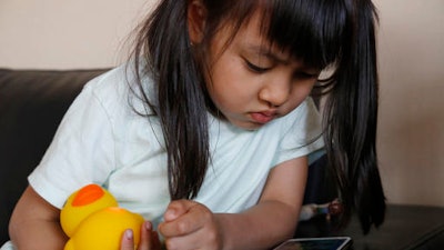 In this May 23, 2016, photo, Kano Matusmoto, 5, plays with Edwin the Duck, a digital duck toy, in the living room of her home in Tokyo. Edwin the Duck, billed as the world’s first “smart duck,” connects by Bluetooth with a smartphone or tablet device such as an iPad to play animation stories and songs. It also works as a regular speaker to deliver music of your choice in bed or in the bathtub.