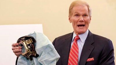 In this Nov. 20, 2014, file photo, Senate Commerce Committee member Sen. Bill Nelson, D-Fla., holds an example of a defective air bag made by Takata of Japan that has been linked to multiple deaths and injuries in cars driven in the U.S., during a hearing on Capitol Hill in Washington.