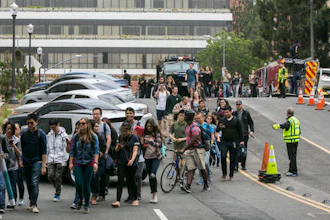 People are evacuated by Los Angeles Police officers from the UCLA campus near the scene of a fatal shooting at the University of California, Los Angeles, Wednesday, June 1, 2016, in Los Angeles. Los Angeles police chief says shooting at UCLA was murder-suicide.