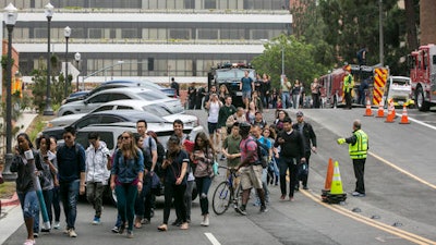 People are evacuated by Los Angeles Police officers from the UCLA campus near the scene of a fatal shooting at the University of California, Los Angeles, Wednesday, June 1, 2016, in Los Angeles. Los Angeles police chief says shooting at UCLA was murder-suicide.