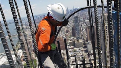 In this Wednesday, June 22, 2016 photo, a worker helps set another load of concrete into the walls of 3 World Trade Center in New York. The World Trade Center's latest new skyscraper has reached its full height of 80 stories.