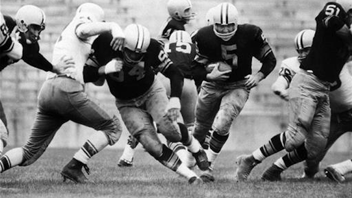 In this Aug. 10, 1959 file photo, Paul Hornung (5) of the Green Bay Packers goes through the line in an inter-squad game in Green Bay, Wis. Pro football Hall of Famer and former Heisman Trophy winner Hornung on Thursday, July 7, 2016, sued equipment manufacturer Riddell Inc., saying their football helmets that he wore during his professional career in the 1950 and ‘60s failed to protect him from brain injury.