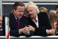 Britain's Prime Minister David Cameron, left, and Virgin boss Richard Branson talk at the Farnborough International Airshow in Farnorough, south England, Monday July 11, 2016. Britain has signed a contract for nine new P-8A Poseidon military aircraft, and Boeing announced Monday a planned expansion for its British operation, as the airshow attracts large international companies to announce their latest plans.