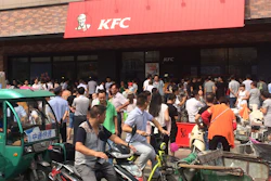 Motorists watch people gather to protest outside a KFC restaurant outlet in Baoying county in east China's Jiangsu province. In an apparent attempt to head off large-scale street demonstrations, Chinese state newspapers have criticized scattered protests against KFC restaurants and other U.S. targets sparked by an international tribunal's ruling that denied Beijing's claim to virtually the entire South China Sea.