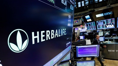 In this file photo, the Herbalife logo appears at the New York Stock Exchange. The Federal Trade Commission is closing an investigation of the multinational, nutritional supplements company as it has agreed to pay $200 million to settle allegations that it deceived consumers.
