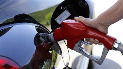 In this Thursday, July 16, 2015, photo, a customer re-fuels her car at a Costco in Robinson Township, Pa. The U.S. government says the fuel economy of the nation’s fleet of cars and trucks likely won’t meet its targets in 2025 because low gas prices have changed the types of vehicles people are buying.