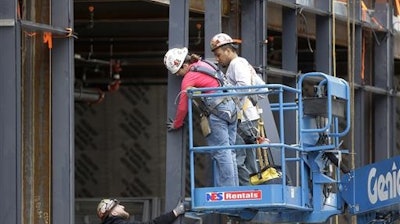 In this Thursday, May 19, 2016, photo, workers construct a building in Boston. On Friday, July 8, the U.S. government issues the June jobs report.