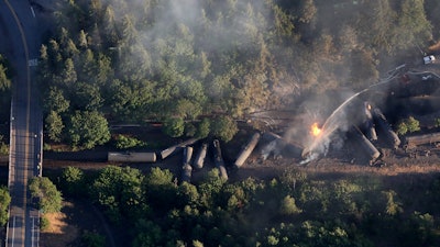 FILE - In this June 3, 2016, file photo, an oil train burns near the town of Mosier, Ore., after derailing. U.S. safety officials say they've seen slow progress in efforts to upgrade or replace tens of thousands of rupture-prone rail cars used to transport oil and ethanol.