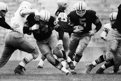 In this Aug. 10, 1959 file photo, Paul Hornung (5) of the Green Bay Packers goes through the line in an inter-squad game in Green Bay, Wis. Pro football Hall of Famer and former Heisman Trophy winner Hornung on Thursday, July 7, 2016, sued equipment manufacturer Riddell Inc., saying their football helmets that he wore during his professional career in the 1950 and ‘60s failed to protect him from brain injury.