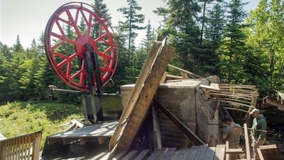 In this Monday, July 11, 2016 photo provided by the Sunday River ski resort, men inspect wreckage of the top unloading terminal of the resort's Spruce Peak Triple ski lift after it detached from the foundation in Newry, Maine. A resort worker first noticed it Sunday evening, and engineers are trying to determine what happened. It was Maine's third major ski resort chairlift failure in six years. The lift was not in operation at the time, and there were no injuries.