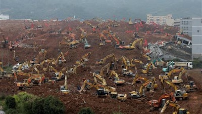 In this Tuesday, Dec. 22, 2015 file photo, rescuers search for potential survivors following a landslide at an industrial park in Shenzhen in south China's Guangdong province. China's Cabinet said Friday, July 15, 2016 that 53 people are in custody in an investigation into the landslide that killed 73 people and left four others missing last year.