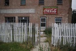 In this July 1, 2016 photo, weeds grow around an old building and picket fence in Rocky Ford, Colo., in Otero County, a rural and increasingly impoverished part of southern Colorado. Two different economic worlds are writ large in this state. It is among those with the greatest economic gap between urban and rural areas, according to an Associated Press review of Economic Innovation Group data.