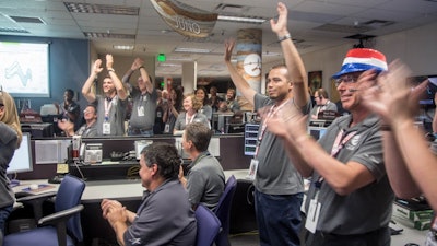 Engineers at Lockheed Martin celebrate after monitoring NASA’s Juno spacecraft as it goes into orbit at Jupiter.