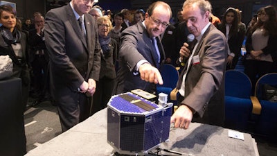 In this Wednesday, Nov. 12, 2014 file photo, French President Francois Hollande, center, with French astrophysicist Francis Rocard look at a model of Rosetta lander Philae, as they visit the Cite des Sciences at La Villette in Paris during a broadcast of the Rosetta mission as it orbits around comet 67/P Churyumov-Gersimenko.