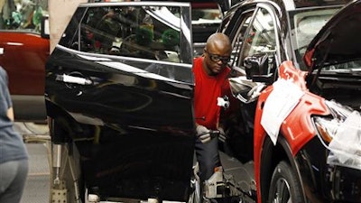 In this April 6, 2016, photograph, a technician works on a door assembly for a Nissan Altima on the line at the Nissan Canton Vehicle Assembly Plant in Canton, Miss. On Tuesday, July 5, 2016, the Commerce Department reports on U.S. factory orders for May.