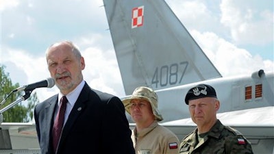 Polish Defense Minister Antoni Macierewicz speaks in front of a Polish Air Force F-16 fighter jet during a farewell ceremony of Polish soldiers leaving for Kuwait to take part in the operation Inherent Resolve , in Janow, Poland, Monday, July 4, 2016. During an interview Monday Macierewicz told The Associated Press that decisions to be approved at this week's NATO summit in Warsaw will build a force aimed at deterring any aggressive intentions by Russia against the West.