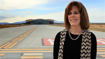In this Dec. 9, 2014, file photo, Christine Anderson, executive director of the New Mexico Spaceport Authority, poses for a photo at the end of the taxiway at Spaceport America in Upham, N.M. Anderson is resigning, saying she still believes in the commercial space industry and that Spaceport America has a role to play. Anderson announced her resignation in a memo sent Tuesday, July 19, 2016, to the authority's board of directors and New Mexico Gov. Susana Martinez.