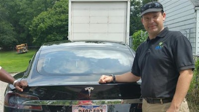 In this 2015 file photo provided by his neighbor, Krista Kitchen, Joshua Brown stands by his new Tesla electric car near his home in Canton, Ohio. Brown died in an accident in Florida on May 7, 2016 in the first fatality from a car using self-driving technology. According to statements by the government and the automaker, his vehicle's cameras didn't make a distinction between the white side of a turning tractor-trailer and the brightly lit sky while failing to automatically activate its brakes. The National Highway Traffic Safety Administration continues to investigate the crash.