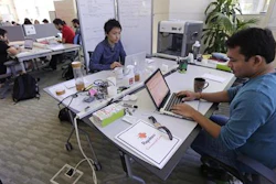 In this Thursday, June 30, 2016 photo, Babson College graduate school alumnus Abhinav Sureka, of Mumbai, India, right, types in his work space at the college in Wellesley, Mass. Some U.S. colleges are starting programs to help their alumni get visas through what critics say is a legal loophole. Foreign grads who want to stay and start a business typically apply for one of the 85,000 H-1B visas that the U.S. gives out each year. But college employees are exempt from that cap, so schools like UMass, Babson and CUNY have launched programs to hire alumni and foreign entrepreneurs and help them grow their businesses here.