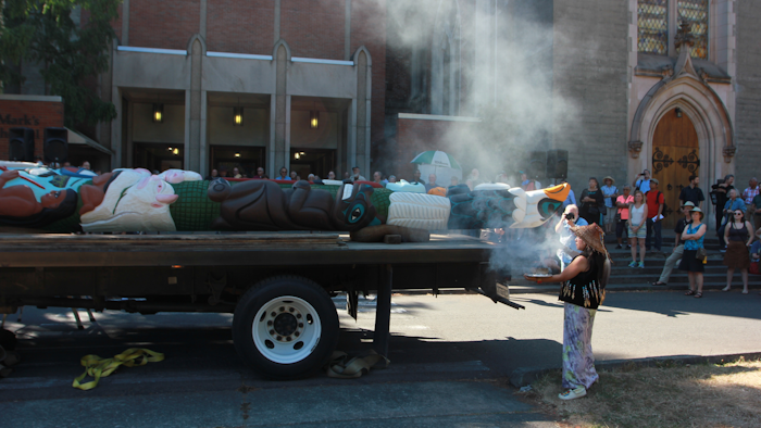 Linda Soriano of the Lummi Nation performs a smudge ceremony at Saint Mark's Episcopal Cathedral in Seattle, fanning smoke from burning sage with eagle feathers onto a totem pole. The 22-foot-tall Lummi Nation totem pole is traveling nearly 5,000 miles across the U.S. and Canada to galvanize opposition to the development of fossil fuel infrastructure, particularly around sea ports in Oregon and Washington.