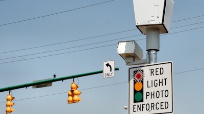 A RedFlex camera takes photos at an intersection.