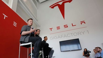 In this Tuesday, July 26, 2016, file photo, Elon Musk, CEO of Tesla Motors Inc., left, discusses the company's new Gigafactory in Sparks, Nev. On Wednesday, Aug. 3, 2016, Tesla reports financial results.