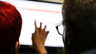 In this Thursday, March 3, 2016, file photo, Georgia Department of Labor services specialist Louis Holliday, right, helps a woman with a job search on a computer at an unemployment office in Atlanta. On Thursday, Aug. 11, the Labor Department reports on the number of people who applied for unemployment benefits in the previous week.