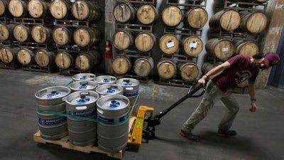 In this Friday, Dec. 11, 2015 file photo, cellerman Franz Graef passes a wall of barrel-aged beers as he pulls a pallet of filled kegs to a walk-in refrigerator at Rhinegeist Brewery in the Over-the-Rhine neighborhood of downtown Cincinnati. Craft brewers in Ohio now have the freedom to make boozier beers. A new state law went into effect Wednesday, Aug. 31, 2016, scrapping caps on alcohol content for beer.