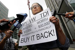 In this Thursday, April 21, 2016, file photo, Joyce Ertel Hulbert, owner of a 2015 Volkswagen Golf TDI, holds a sign while interviewed outside of the Phillip Burton Federal Building in San Francisco.