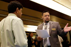In this Tuesday, July 19, 2016, photo, Ronnie Teheran, with Service Corporation International, right, talks with a job applicant at a job fair in Miami Lakes, Fla. Payroll processor ADP reports employment figures for July on Wednesday, Aug. 3, 2016.