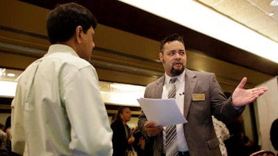 In this Tuesday, July 19, 2016, photo, Ronnie Teheran, with Service Corporation International, right, talks with a job applicant at a job fair in Miami Lakes, Fla. Payroll processor ADP reports employment figures for July on Wednesday, Aug. 3, 2016.