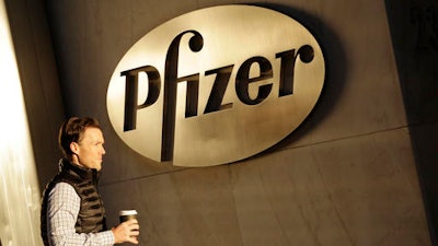 In this Monday, Nov. 23, 2015, file photo, a man enters Pfizer's world headquarters, in New York. Pfizer is buying biopharmaceutical company Medivation in a deal valued at about $14 billion. Medivation Inc.’s stock soared more than 19 percent in Monday, Aug. 22, 2016 premarket trading.