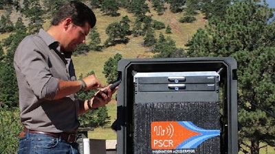 NIST engineer Ben Posthuma demonstrating the use of NIST’s Rapidly Deployable Public Safety Research Platform, a mobile array of commercial technologies that can be set up in strategic locations to enable over 200 local users of broadband smart phones, Wi-Fi, data terminals and older walkie-talkie radios to all communicate with each other. Researchers use this self-contained mobile network for research and demonstration projects to improve public safety communications.