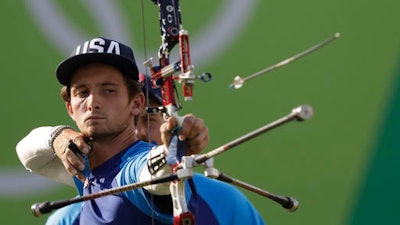 Zach Garrett of the United States releases his arrow during the men's team archery competition at the Sambadrome venue during the 2016 Summer Olympics in Rio de Janeiro, Brazil, Saturday, Aug. 6, 2016.