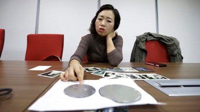 In this March 5, 2016 photo, Park Min-sook, 43, a former Samsung chip worker and a breast cancer survivor, explains how silicon wafers are used in the semiconductor process during an interview in Seoul, South Korea. An Associated Press investigation has found South Korean authorities have, at Samsung’s request, repeatedly withheld crucial information about the chemicals that workers were exposed to at its computer chip and liquid crystal display factories. Workers who have fallen ill due to the chemicals have the right to access such data so they can apply for workers’ compensation from the state. Without this information, government officials commonly reject their cases.