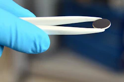 A slice of (white) lithium garnet electrolyte coated with a (black) lithium compound acting as the battery's minus pole in the laboratory of the ETH researchers.