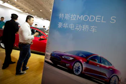 In this April 25, 2016, file photo, visitors look at a Tesla Model S electric car on display at the Beijing International Automotive Exhibition in Beijing. Tesla said August 15, 2016, that the removal of the term autopilot from its website for China was a mistake and the term is being restored.