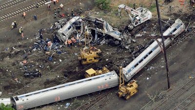 In this Wednesday, May 13, 2015 file photo, emergency personnel work at the scene of a derailment in Philadelphia of an Amtrak train headed to New York. Many commuter and freight railroads have made little progress installing safety technology designed to prevent deadly collisions and derailments despite a mandate from Congress, according to a government report released Wednesday, Aug. 17, 2016.