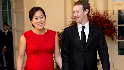 In this Friday, Sept. 25, 2015, file photo, Facebook Chairman and CEO Mark Zuckerberg and his wife, Priscilla Chan, arrive for a State Dinner in honor of Chinese President Xi Jinping, in the East Room of the White House in Washington. Despite no national law, paid family leave benefits are rising in some business sectors and regions thanks to company policy and laws. A majority of Americans over 40 support paid leave to care for family. Highly visible executives, like Zuckerberg, have spoken out in favor of paid family leave laws. He announced with a status update on Facebook that he was taking two months of parental leave to help care for his new daughter. Facebook offers 16 weeks of paid leave to new mothers and fathers.