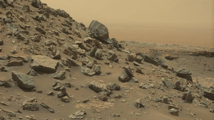 This view from the Mast Camera (Mastcam) in NASA's Curiosity Mars rover shows a sloping hillside within the Murray Buttes region on lower Mount Sharp. The rim of Gale Crater, where the rover has been active since landing in 2012, is visible in the distance. The image was taken on Sept. 8, 2016, during the 1454th Martian day, or sol, of Curiosity's work on Mars.