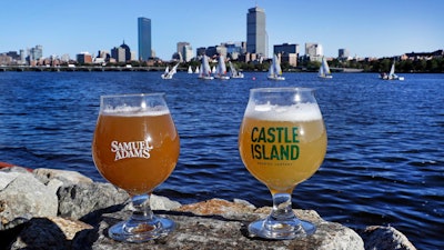 A glass of Samuel Adams Boston Beer Company '80-Miles of Helles' beer, left, and a glass of Castle Island Brewing Company 'Chuck, dry hopped cream ale rest on a rock along the bank of the Charles River. Both beers are made using Charles River water.