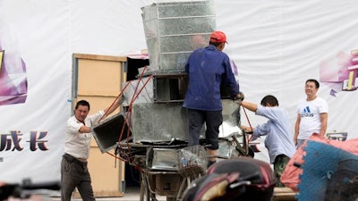 Workers remove air ducts made from aluminum sheet metal in Beijing, China. China’s leaders are promising to rein in aluminum production that is flooding global markets and threatening jobs in the United States and Europe, but its producers have ambitious plans to expand.