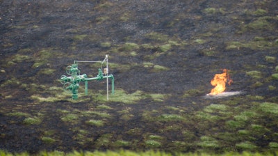 FILE – In this April 29, 2016, file photo, a flame flickers near pipes in the charred ground and trees where a natural gas explosion at a pipeline damaged houses in Salem Township, Pa. The blast scorched 40 acres and badly burned a man whose home was destroyed.